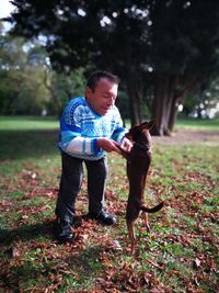 Dwarf man playing with dog at park