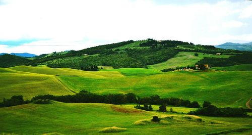 Scenic view of grassy field against cloudy sky