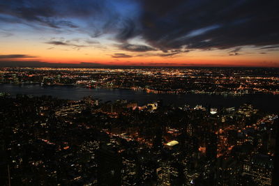 Aerial view of illuminated city at sunset