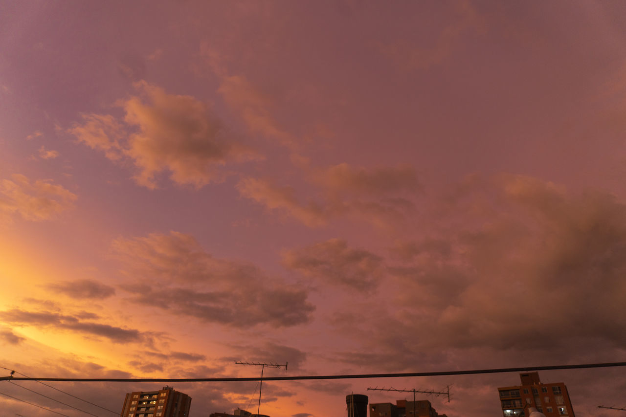 LOW ANGLE VIEW OF DRAMATIC SKY OVER SILHOUETTE BUILDINGS