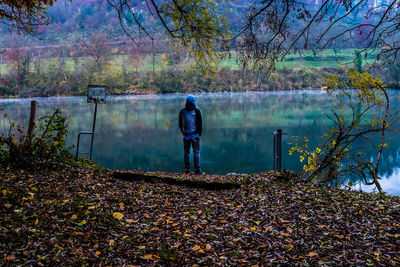 Rear view of man standing by autumn leaves