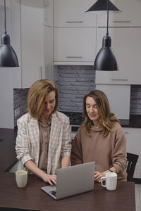 Young woman using laptop at table