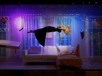 Reflection of man and woman standing on glass table