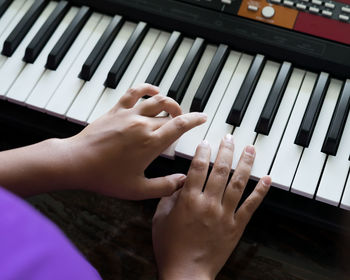 Happy cute boy playing piano at home