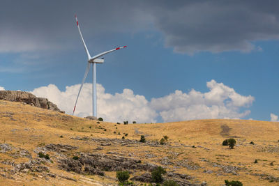 Windmill on field against sky