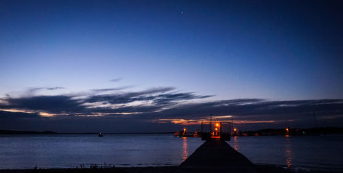 Silhouette of pier at harbor during sunset