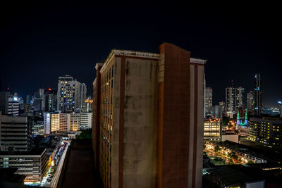 Illuminated buildings in city against sky at night