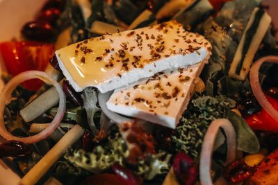 Close up vegetable salad with a large piece of cheese with olive oil and spices