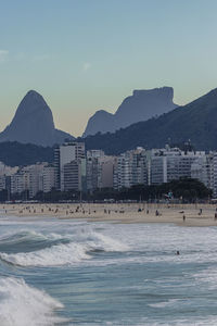 Scenic view of sea by buildings against sky