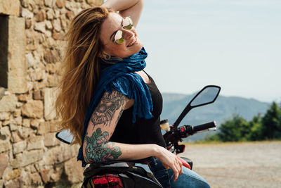 Midsection of woman sitting outdoors