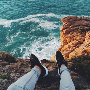 Low section view of person sitting at coast