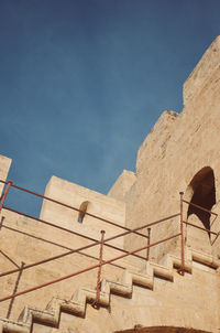 Low angle view of old ruins against clear blue sky