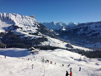 People on snowcapped mountains against sky