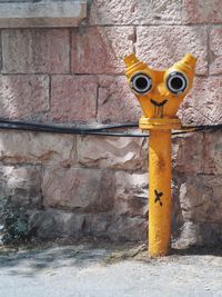 Close-up of fire hydrant against brick wall