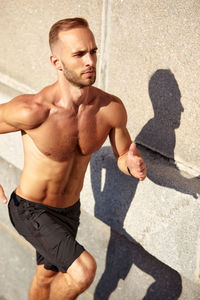 Portrait of shirtless man standing on street