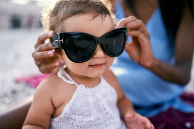 Midsection of woman holding sunglasses