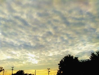 Low angle view of silhouette trees against dramatic sky