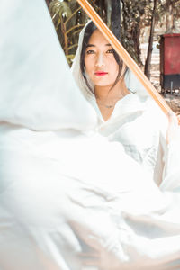 Portrait of young woman sitting on bed