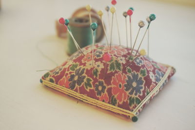 Close-up of colorful thumbtacks on pin cushion