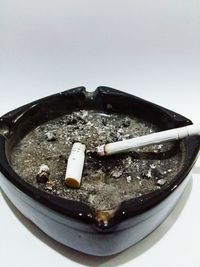 Close-up of cigarette smoking over white background