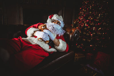 Man wearing santa claus costume sleeping on sofa at home