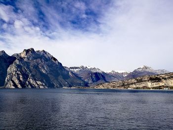 Scenic view of lake by mountains against sky