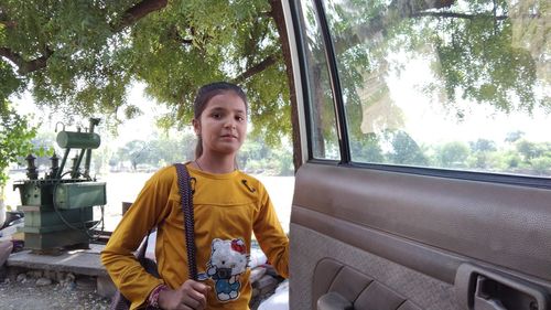 Portrait of smiling young woman sitting in car