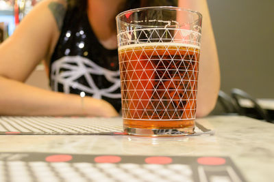 Close-up of woman with drink in glass on table