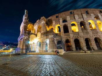 Low angle view of illuminated building against sky at night