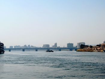 Scenic view of sea and buildings against clear sky