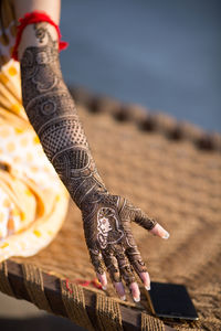 Midsection of woman showing henna tattoo