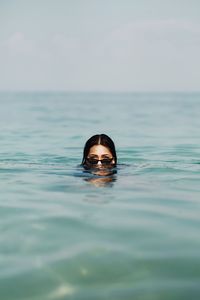 Woman swimming in sea against sky