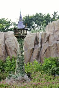 Stone wall by rock formation against sky