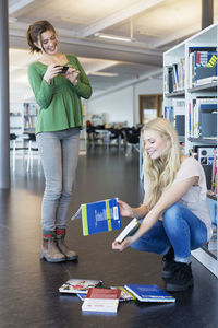 Full length of female friends in school library