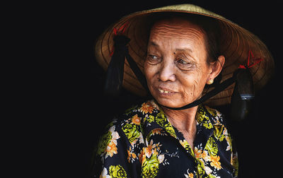 Portrait of smiling woman against black background