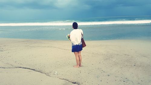 Rear view of man standing on beach