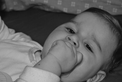 Portrait of cute baby girl lying on bed