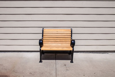 Empty bench against wall