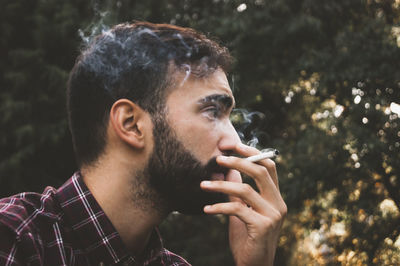 Close-up of young man smoking outdoors