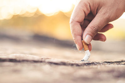 Men hand caught a burning cigarette causing smoke, concept stop smoking.