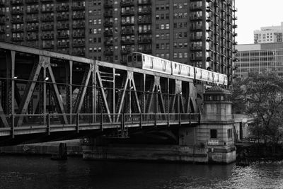 Bridge over river against buildings in city