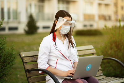 Young woman using laptop while sitting on table