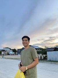 Low angle view of young man standing against sky