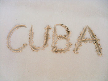 High angle view of cuba written on sandy beach