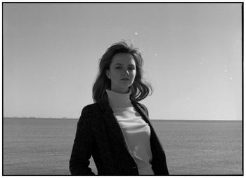 Portrait of young woman against sea and clear sky