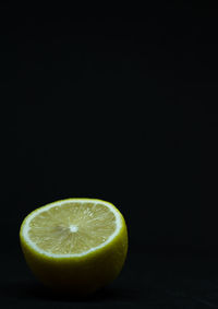 Close-up of lemon slice on table against black background
