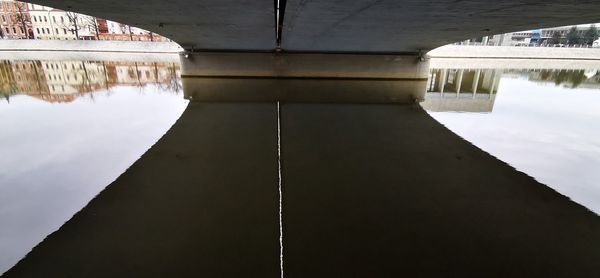 Reflection of bridge in lake against sky