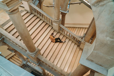 High angle view of man using mobile phone sitting on steps