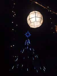 Low angle view of illuminated lights against sky at night