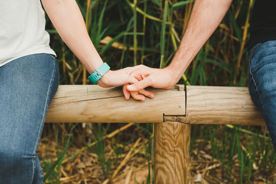 Midsection of man with hands on wood